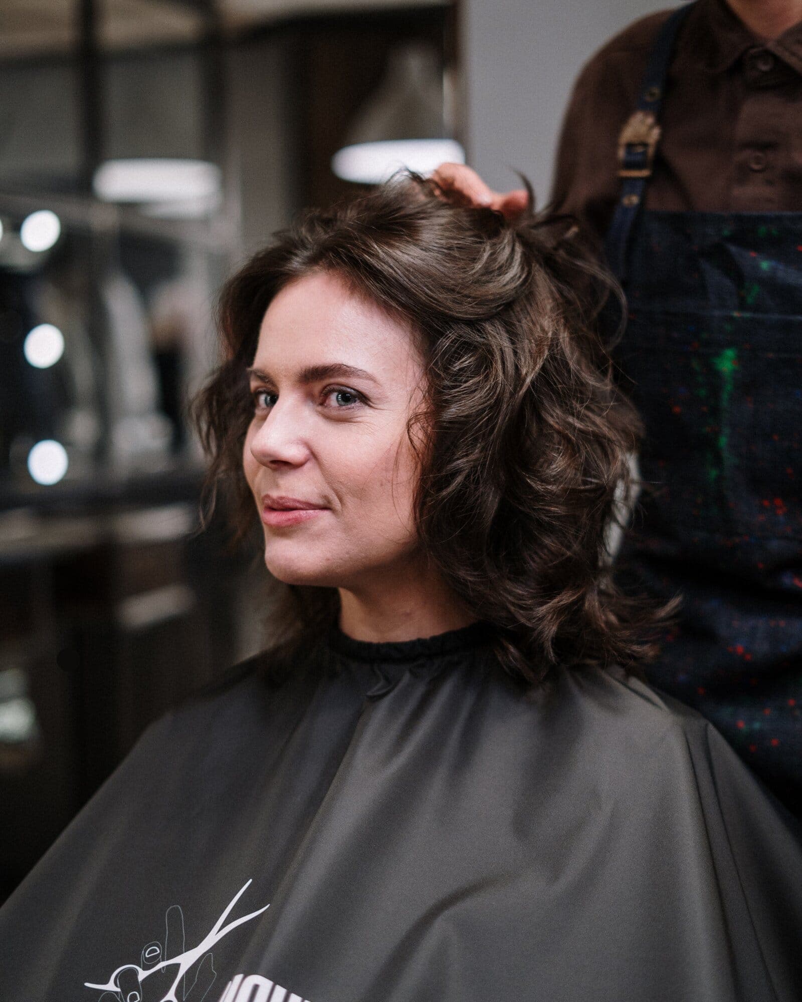 A stylist finishing a client's curls in a hair salon